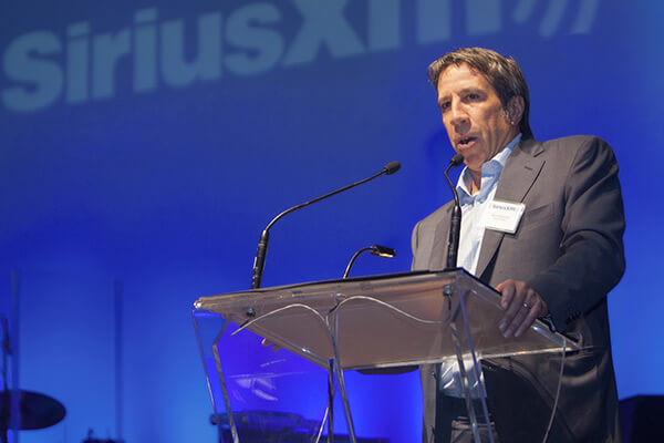 SiriusXM Canada's President and CEO Mark Redmond giving a presentation on stage.