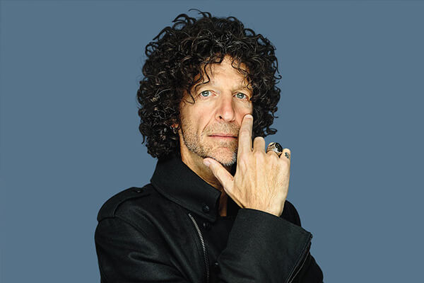 An thoughtful image of Howard Stern with his head resting in one of his hands.
